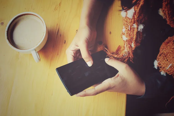 Жінка п'є каву зі смартфоном і штрихом — стокове фото