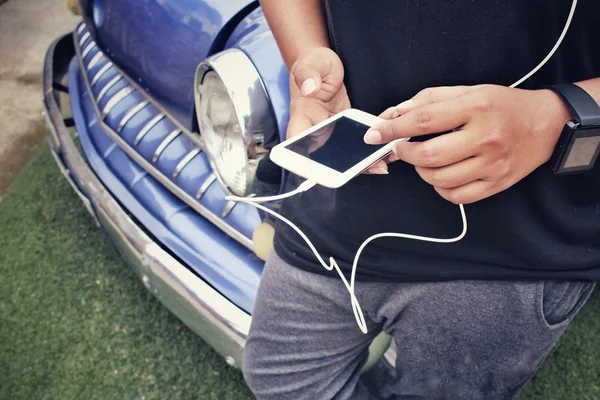 Mulher ouvindo música no fone de ouvido com telefone inteligente — Fotografia de Stock