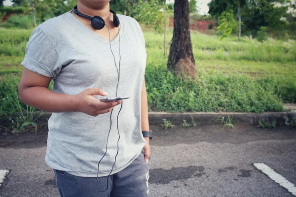 스마트 폰으로 이어폰에서 음악을 듣고 하는 여자 — 스톡 사진