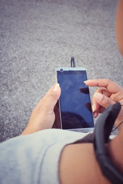 Frau hört Musik über Kopfhörer mit Smartphone — Stockfoto