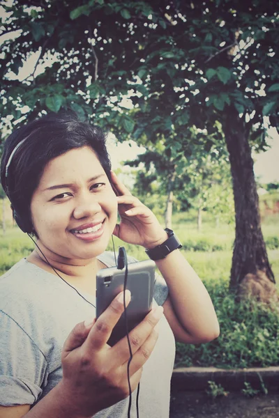 Woman listening to music on earphone with smart phone — Stock Photo, Image