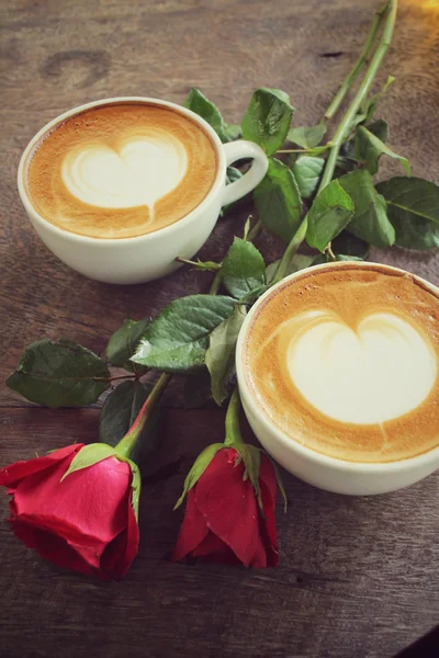 Duas xícaras de café arte latte com rosa vermelha — Fotografia de Stock