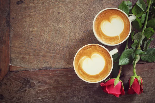 Twee kopjes latte art koffie met rode roos — Stockfoto