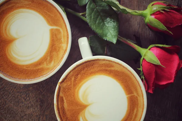 Két csésze kávé, piros rózsával latte art — Stock Fotó