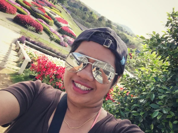 Selfie de mujer sonrisa con flores jardín —  Fotos de Stock