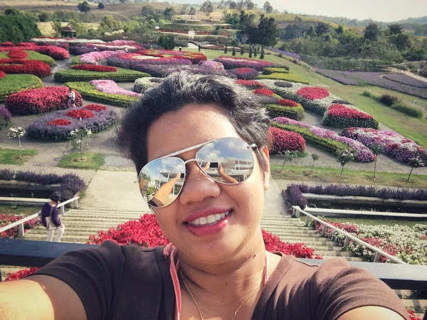 Selfie žena úsměv s květiny zahrada — Stock fotografie