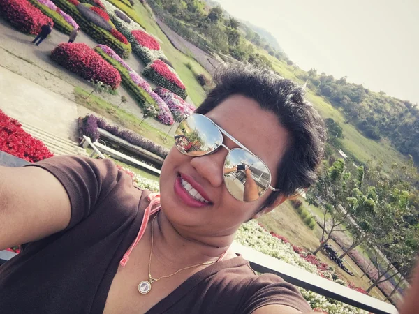Selfie žena úsměv s květiny zahrada — Stock fotografie