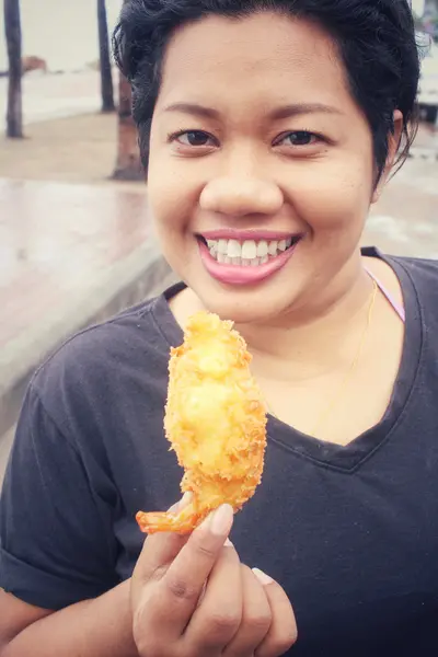 Mulher comendo camarão frito — Fotografia de Stock