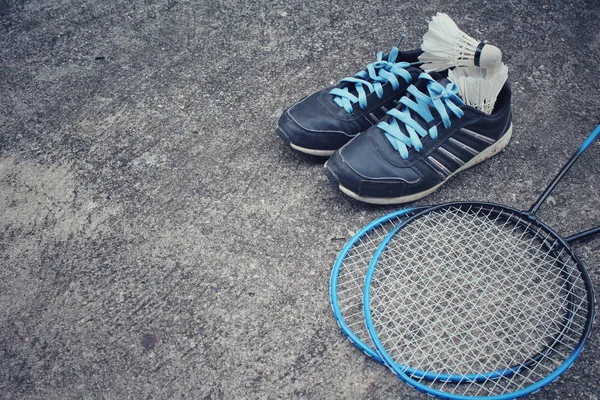 Chaussures de sport avec navettes et raquette de badminton . — Photo