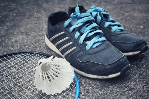 Chaussures de sport avec navettes et raquette de badminton . — Photo