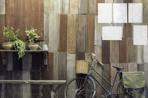 Bicicletta vintage e piccolo albero su sfondo vecchio muro di legno Foto Stock Royalty Free