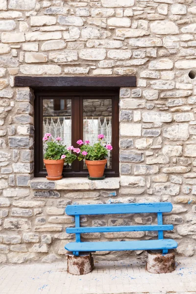 Blumenfenster und blaue Bank — Stockfoto