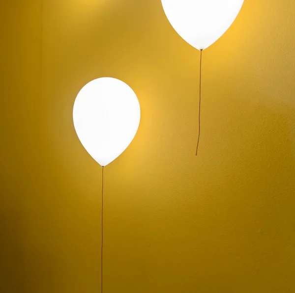 Lampe en forme de ballon sur mur jaune — Photo