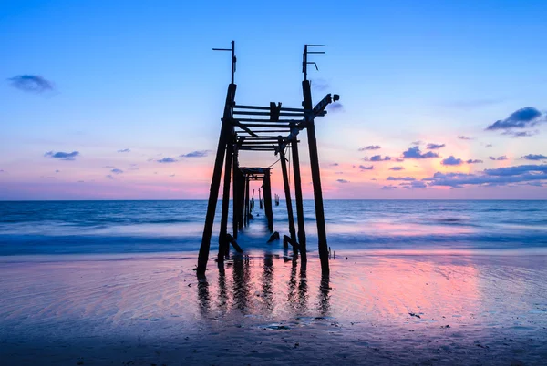 Colorata spiaggia al tramonto con molo di legno abbandonato — Foto Stock