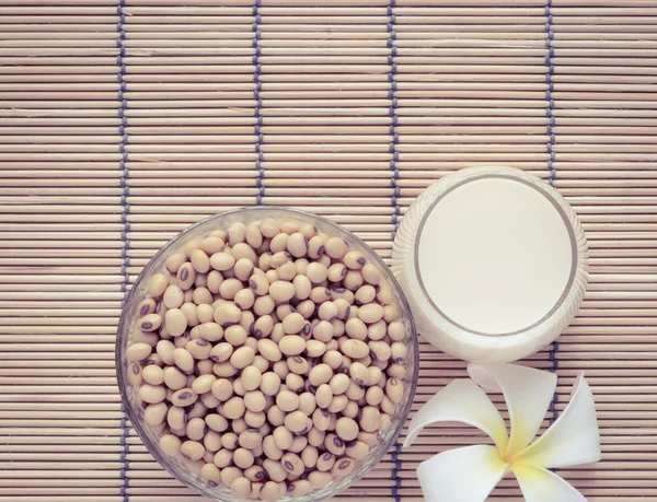 Latte di soia fresco (latte di soia) in un bicchiere e semi di soia — Foto Stock