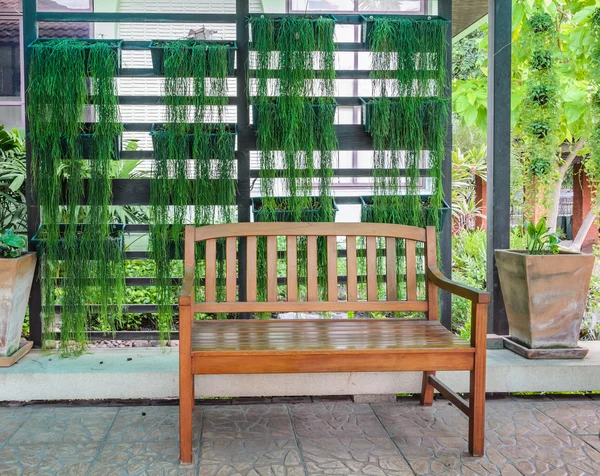 Banco de pátio de madeira com plantas verdes fundo — Fotografia de Stock