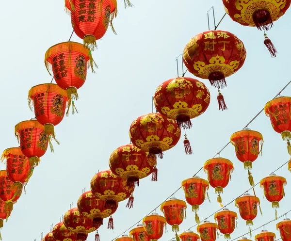 Lanternas vermelhas chinesas penduradas no céu azul — Fotografia de Stock