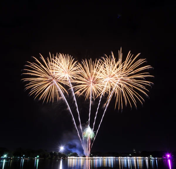 Fogos de artifício amarelos com luzes de reflexão no lago — Fotografia de Stock