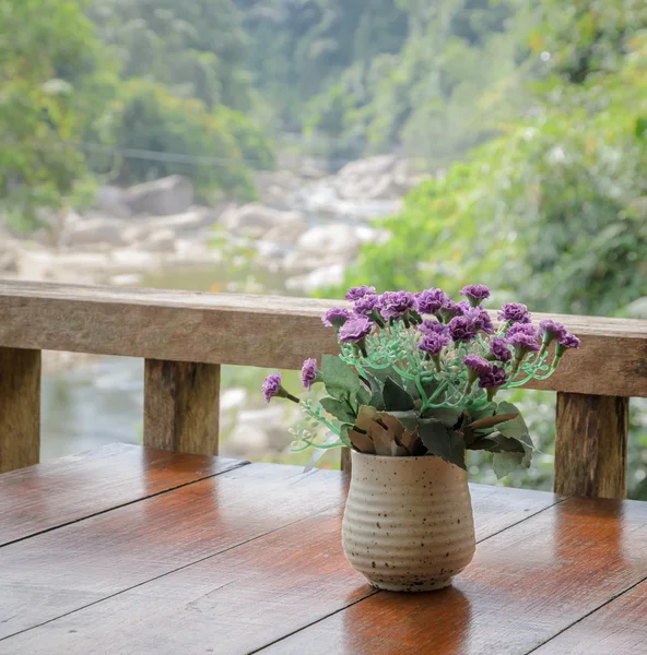 Fioletowy kwiat na drewnianym stole — Zdjęcie stockowe