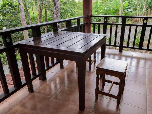 Dřevěné křeslo a stůl na terase — Stock fotografie