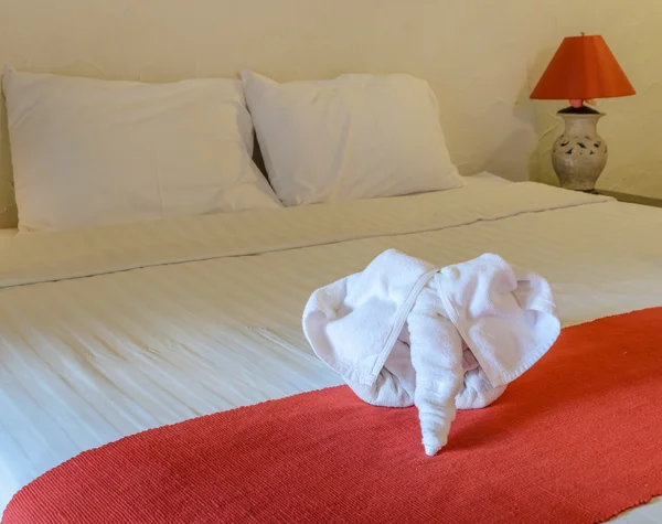 Toalla blanca en forma de elefante en la cama — Foto de Stock