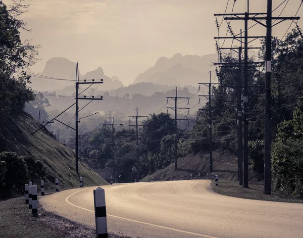 Асфальтована крива дороги з гірським тлом у вінтажному стилі — стокове фото