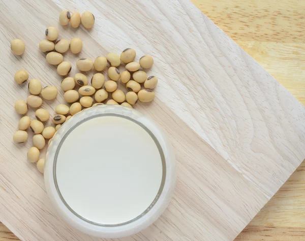 Latte di soia fresco (latte di soia) in un bicchiere e semi di soia — Foto Stock