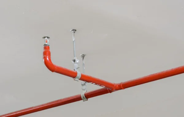 Fire sprinkler and red pipe on ceiling — Stock Photo, Image