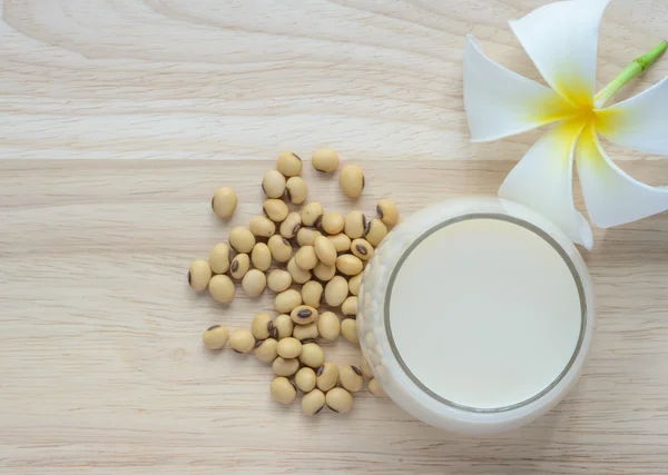 Latte di soia fresco in un bicchiere e semi di soia — Foto Stock