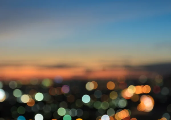 Luzes borradas da cidade bokeh iluminado ao crepúsculo — Fotografia de Stock