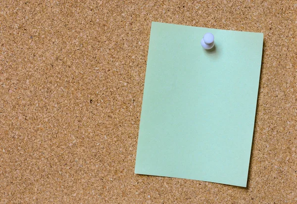 Blank green note pinned on cork board — Stock Photo, Image