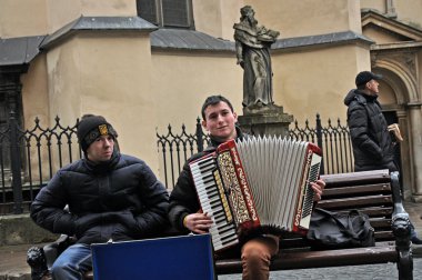 Lviv, Ukrayna-Ocak 24, 2015: sokak müzisyen şehir Lviv merkezi meydanında oynuyor