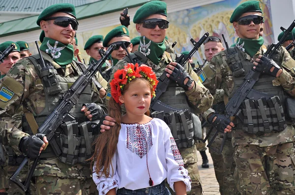 Kiev, Oekraïne - 24 augustus 2014: Het jonge meisje in nationale klederdracht poseren omringd door soldaten in de dag van de onafhankelijkheid van Oekraïne — Stockfoto