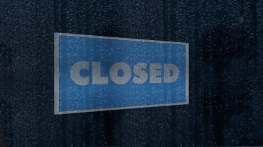 Mavi renkli mi, kapalı mı? Yağmurlu bir cam yüzeydeki işaret kasvetli ve kasvetli bir atmosfer yaratıyor. Damlacıklar ve sessiz ışıklandırma yokluğu, duraksamayı ve bir mağaza vitrininin önündeki sessiz anı vurgular..