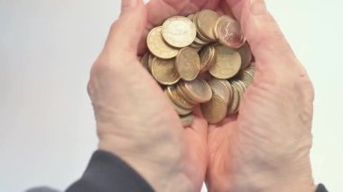 Bir yığın bozuk parayı, tasarruf, bütçe ve finansal bakımı toplayan yaşlı ellere yakın çekim. Emeklilik fonlarıyla, aile desteğiyle ve finansal durumla ilgili hikayeler için ideal..