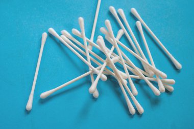 Parlak mavi arkaplanda beyaz pamuklu çubuklar var. Kişisel bakım, hijyen, cilt bakımı ve tuvalet rutin fikirleri için mükemmel..