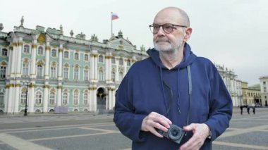 Üst düzey bir adam, Moskova 'daki Hermitage Müzesi' ni ve tarihi barok mimarisini gündüz gezisi ve turizm ziyareti sırasında fotoğraflamak için dijital kamera kullanıyor.