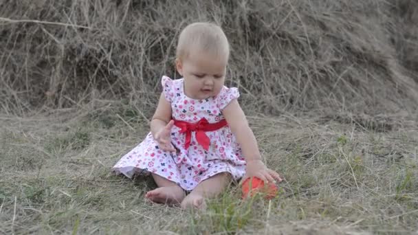 小さな女の子がおもちゃ、芝生の上で遊んで. — ストック動画