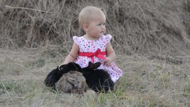 Mignon belle rire adolescent fille sur herbe avec blanc et noir bébé lapin — Video