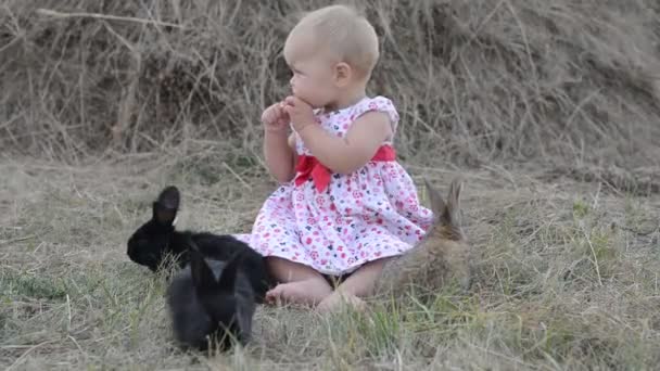 Mignon belle rire adolescent fille sur herbe avec blanc et noir bébé lapin — Video