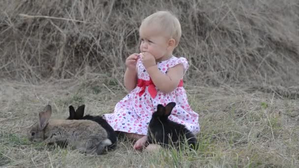 Mignon belle rire adolescent fille sur herbe avec blanc et noir bébé lapin — Video