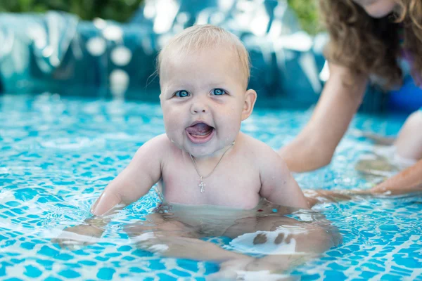 A cute happy young female girl child baby relaxing on the side of a swimming pool — Stock Photo, Image