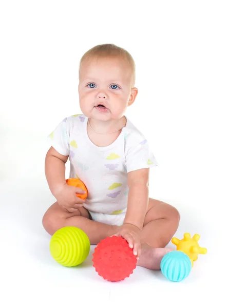 Очаровательный ребенок играет с красочным пляжным мячом, изолированный на белом — стоковое фото