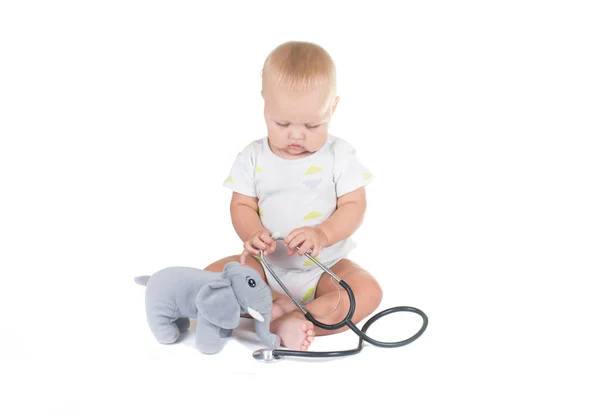 Bedårande barn klädd som läkare leker med leksak isolerade på vit bakgrund — Stockfoto