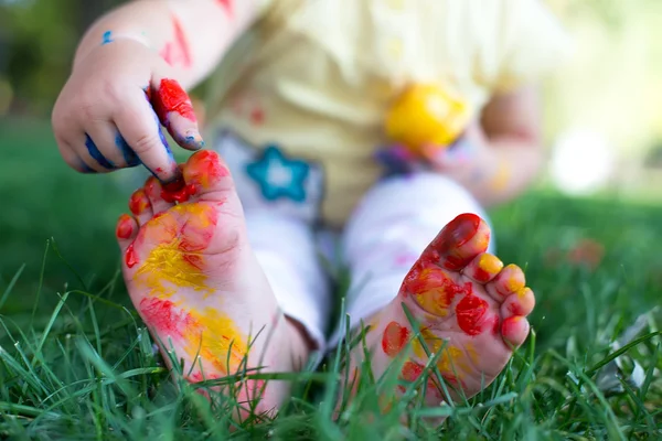 Couple lying on green grass. Children having fun outdoors in spring park — Stock Photo, Image