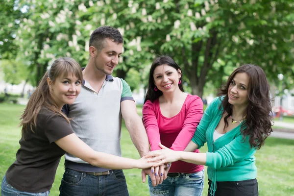 Gelukkig tiener groep met handen op stapel — Stockfoto