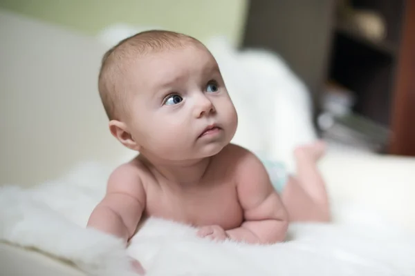 The surprised baby lying on white towel — Stock Photo, Image