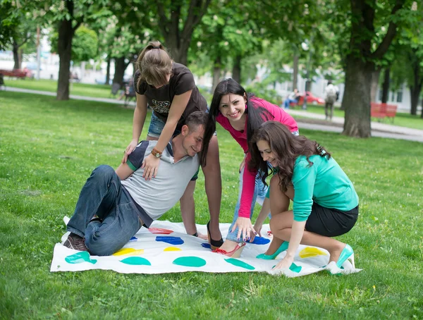 Studenten spelen een spel in de park twister — Stockfoto