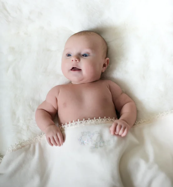 The surprised baby lying on white towel — Stock Photo, Image