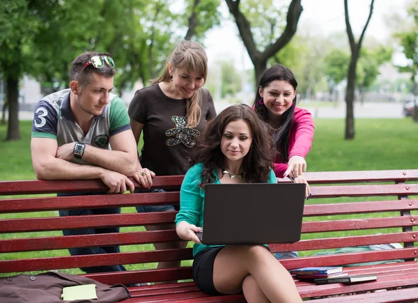 Grupo de jovens estudantes universitários usando laptop — Fotografia de Stock
